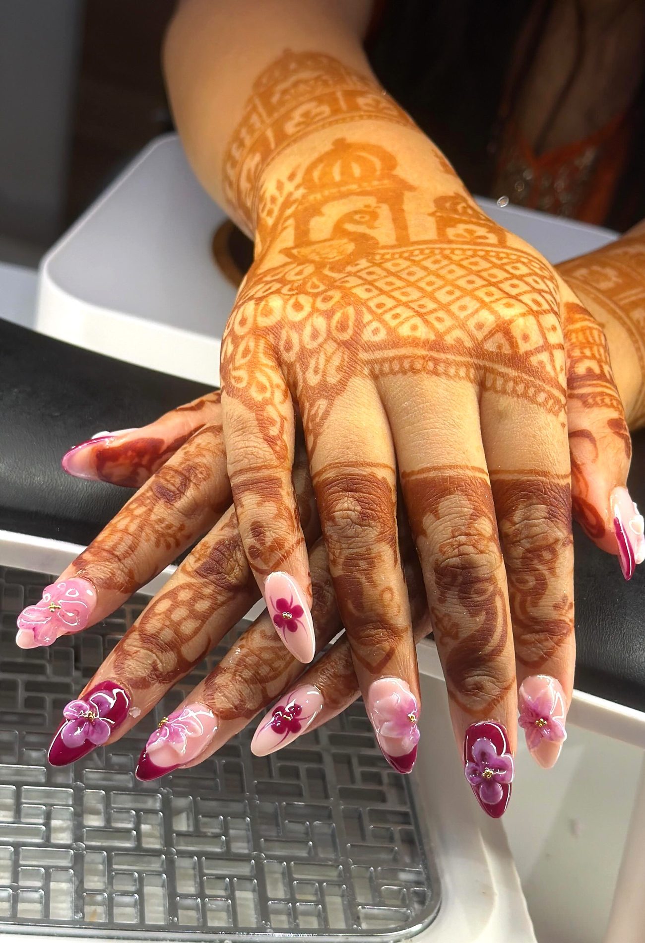 Bridal mehndi hands with pink and maroon 3D flower nail extensions at Mirror Beauty Studio, Ujjain