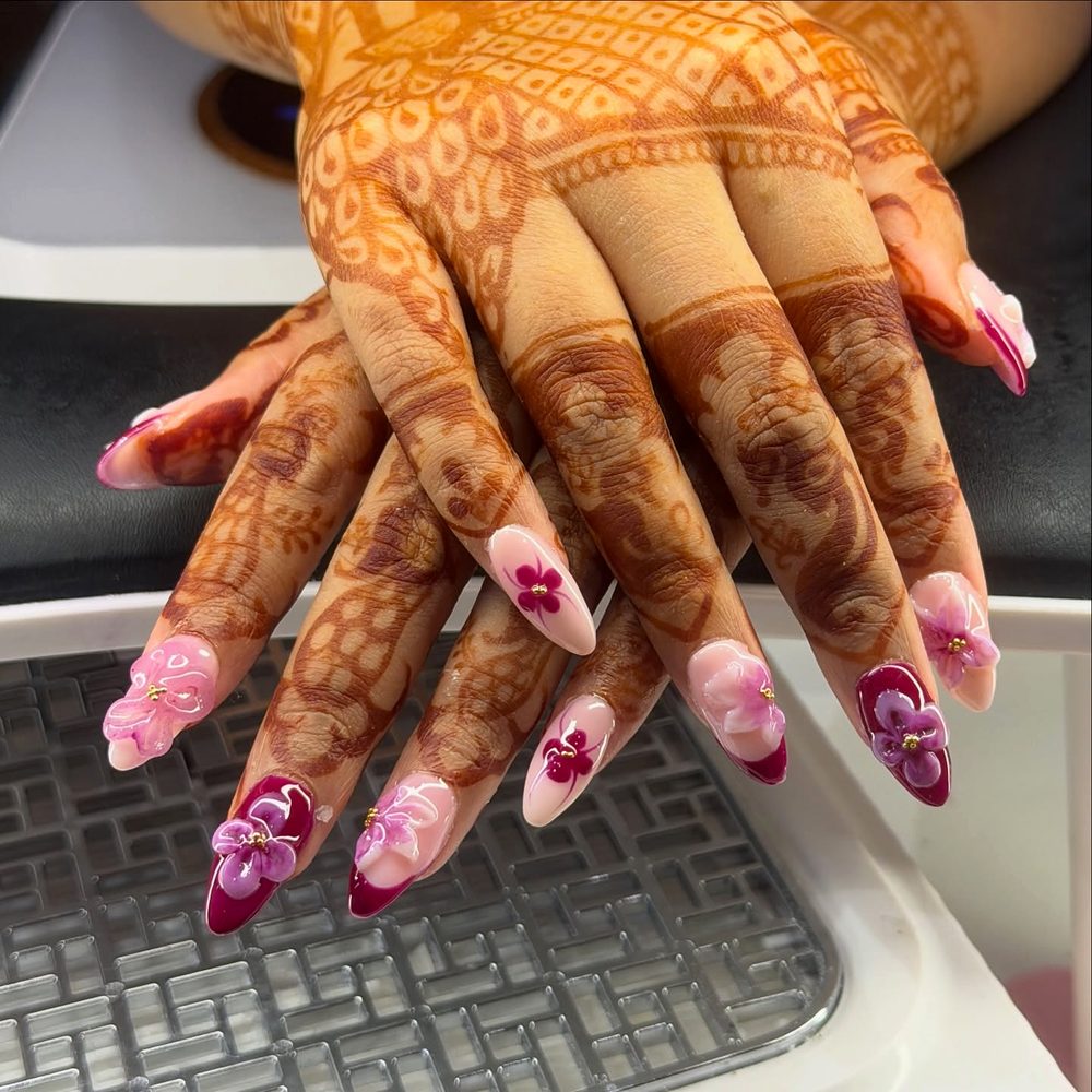 Pink 3D flower nail extensions on bridal mehndi hands